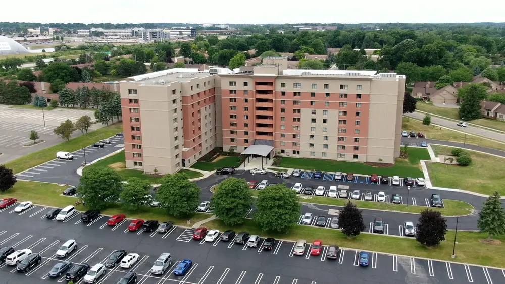 Aerial shot of a multi-story apartment building using beige Dryvit EIFS and red NewBrick exterior cladding. 